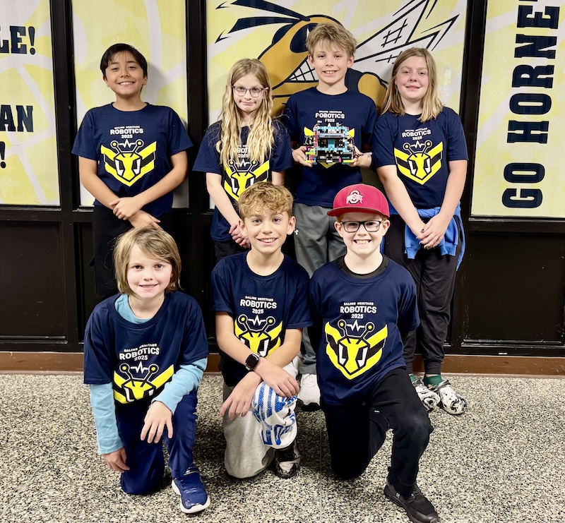 The 2025 RoboSwarm Team includes Esteban, Cora, Ben, Etta in the back row. In the front row are Ellie, Kieran, and Dominic.
